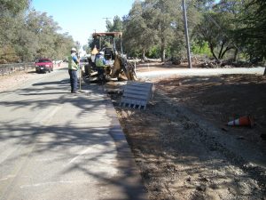 men and equipment working on road